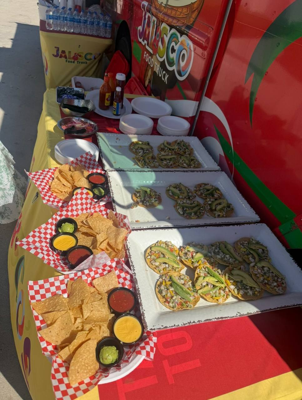 Outdoor appetizer display with tostadas, chips, and salsas at a Jalisco Food Truck event