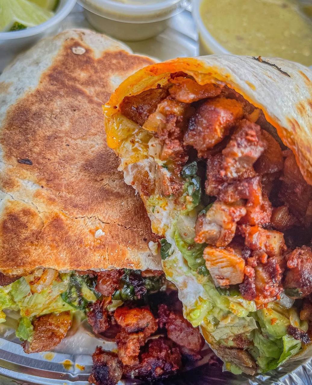 Loaded burrito cut open showing seasoned meat, cheese, lettuce at Jalisco Food Truck Bastrop TX