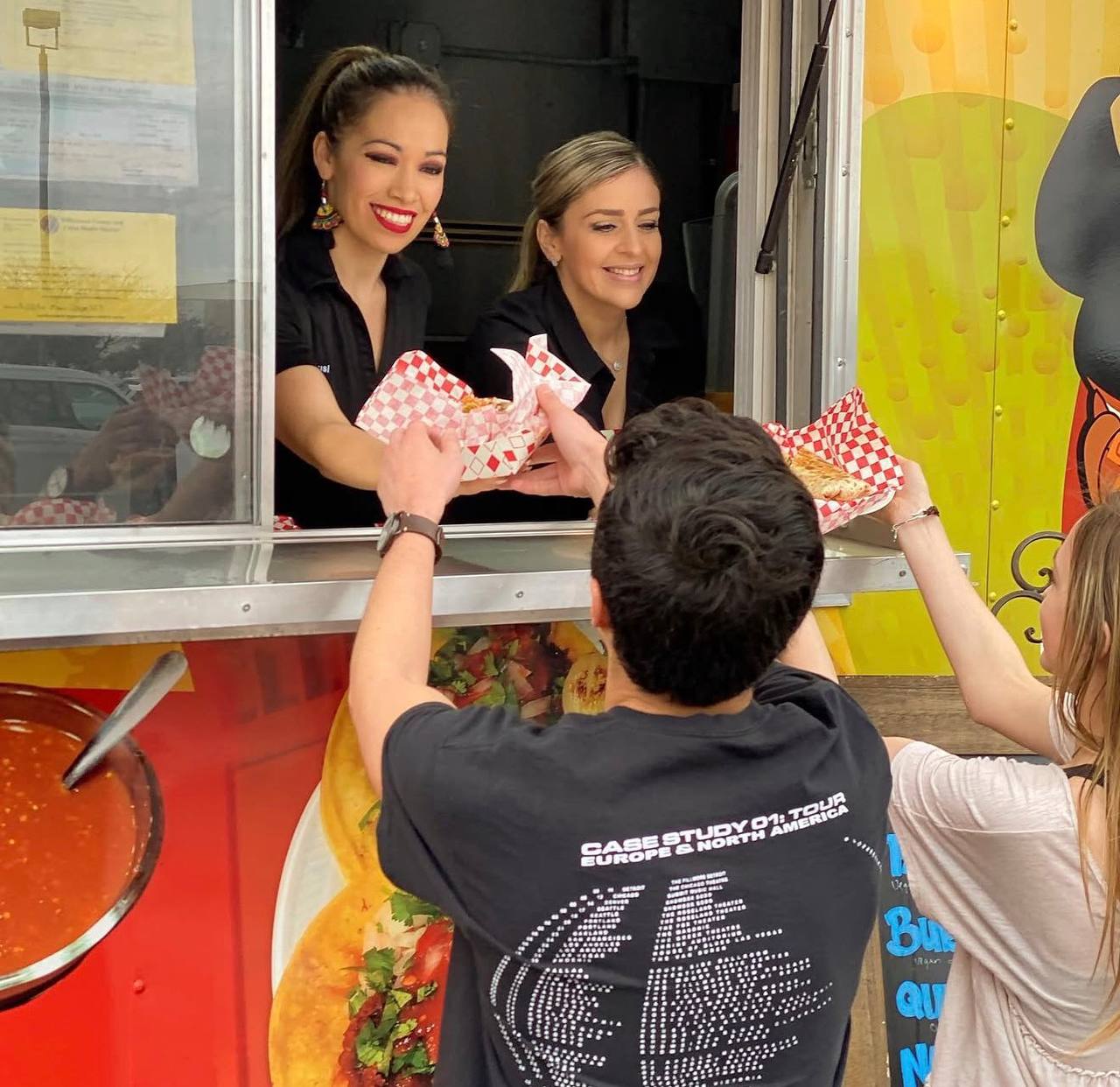 Jalisco Food Truck staff smiling and handing food to happy customers in Bastrop TX